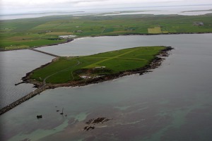 Ostrůvek Lamb Hom, Orkneje – vlevo nahoře je Churchillova hráz číslo 1, kudy do Scapa Flow v říjnu  1939 vplula německá ponorka, která následně potopila britskou válečnou loď Royal Oak s níž   zahynulo i 833 britských vojáků. Na ostrůvku jsou zřetelně viditelné přistávací dráhy soukromého   letiště, kde jsem přistál.