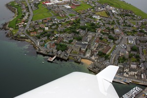 Přístav a střed města Lerwick. Černobílá loď je botel. V současné době je na Shetlandských  ostrovech nedostatek ubytování pro pracovníky na těžebních plošinách v Severním moři a tak   je využíváno a takovéto náhradní řešení.