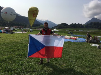Prostranství před Château de Gruyères. Aleš s českou vlajkou před místem, kde zanedlouho bude k nebi čnít balón českého týmu. Zdroj: @DvaFousaci 