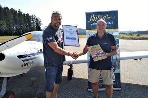 Luboš Rafaj z Agentury Dobrý den Pelhřimov předává Jiřímu Prušovi certifikát potvrzující dosažení přistání na 500 různých letištích světa. 