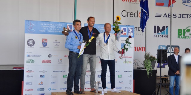 Třída 18m:  1. Wolfgang Janowitch (Rak.), 2. Mario Kiessling (Něm.), 3. Jean-Denis Barrois (Fr.). MS v bezmotorovém létání 2018, Hosín. Zdroj: www.wgc2018.cz