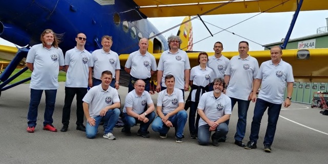 Misijní tým před odletem z Jihlavy ve čtvrtek 6. 6. 2019. Zleva stojí:  Libor Paszek - mechanik, Jihlava Air Service, Viktor Wildner - spolupracovník CSC, František Mikulík - člen výboru - ekonom CSC, Pavel Slavík – letecký historik, čestný člen CSC, Jiří Soukup – letecký historik, Art Gallery Jindřichův Hradec, Marie Kratochvílová – logistika, CSC, Mgr. David Šterba – pilot - navigátor An-2, Jihlava Air Service, Zdeněk Sadecký - předseda CSC, Jaroslav Kaprál velitel -pilot An-2, Jihlava Air Service. Zleva v podřepu: Zbyněk Smetana – kameraman, Airzone TV, Petr Radoch - spolupracovník, Jiří Hofmann - spolupracovník CSC, Jan Dvořák – redaktor, Flying Revue.