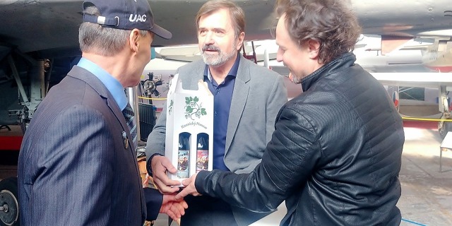 Jedna z duší zorganizování Kvočurovy návštěvy, Josef Říha  z Českého svazu letectví, předává oběma pilotům speciální letecké pivo.