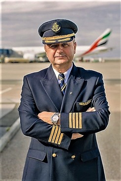 Miroslav Srnec v uniformě kapitána Emirates, za ním jeho stroj B777-300ER. 