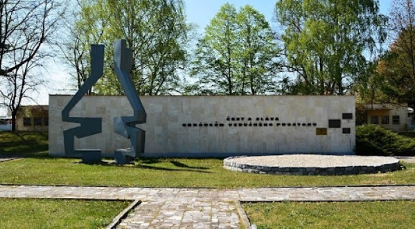 Zeď památníku s nápisem: Čest a sláva obráncům vzdušného prostoru. Na pravé straně jsou pamětní plakety