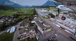 Přiblížení na přistání přes střechy domů. To je letiště Kägiswill