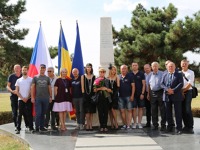 Ozvěny první etapy. Společné foto všech účastníků Vzpomínkového letu s jeho hostiteli u památníku CFRNA/CIDNA před letištěm. Stejný památník stojí i u Terminálu 3 Letiště Václava Havla. 5v2a5257_1280x853_-min.jpg